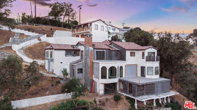 1648 Summitridge Drive Beverly Hills, California Tucked away in Beverly Hills behind a private gated driveway, this construction-ready estate offers the opportunity to create an elegant hideaway in one of the worlds most covetable postal codes. With 4,346 square feet across 3 floors, the main residence boasts 4 ensuite bedrooms, an expansive living area awash in natural light and breathtaking views of the canyon and city skyline. An entertainers dream, the main level features a chefs kitchen, formal dining area, and outdoor patio. Downstairs discover a full bar, 800-bottle wine cellar, half bath and space for a screening room. On the top level, find sanctuary in the luxuriously oversized primary suite, complete with a sweeping balcony. Additional features include a recently widened driveway, ample parking and a 3-car garage below a large guest house with its own bedroom and bathroom. Just down the road, enjoy nearby trails and access to beloved pockets of L.A. Welcome to an enchanting estate with endless potential.