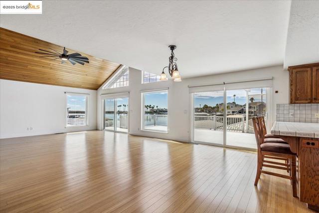 Unfurnished dining area featuring wood ceiling, light wood-style floors, a chandelier, a textured ceiling, and a ceiling fan