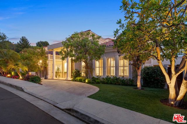 2151 RAVENSFIELD Lane Los Angeles, California Sited behind the exclusive guard gates of Bel Air Crest, this home is one of 200 luxury estates in one of the most sought-after communities in Los Angeles. Over 7,000 SF of a custom home, the craftsmanship and attention to detail communicate from the stained glass skylight to the hand-carved antique wooden doors. A grand two-story entryway is framed with dual staircases, inlaid art walls, coffered ceilings, and a chandelier centerpiece leading to the spacious rooms of a thoughtfully open floor plan. A gourmet kitchen with wooden floors, the finest appliances, a chef's island, and breakfast nook, a formal dining, formal living, oversized great room with a fireplace, wet bar, and french doors opening to the wrap-around back deck, a powder and en suite bedroom complete the main level. Upstairs offers three additional bedrooms w/office option, and a royal primary bedroom hosts a fireplace to separate a lounge sitting area, dual sinks and dual walk-in closets, a vanity, soaking tub, and standing shower, all overlooking the backyard oasis. Luxurious amenities welcome you on the lower level with a brick, temperature-controlled wine tasting room, two gym areas, a music studio, a theater with tiered seating for 15+, an elevator to all three floors, and an ensuite in-law bedroom with a separate entrance from the pool deck. The backyard grounds offer lush serenity for intimate relaxation and a pool, spa, waterfall with fire pits, and BBQ sitting areas perfect for entertaining. This rare opportunity for sale in the coveted Bel Air Crest community gives private neighborhood living with a sophisticated and quality build.