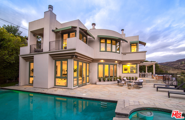 930 N Tigertail Road Los Angeles, California Beautifully remodeled contemporary Mediterranean home located in Brentwood with extraordinary unobstructed views of the Pacific Ocean, city lights, canyon, and the Getty Museum. The entryway makes a bold statement with vaulted ceilings, intricately scrolled ironwork, and stark white walls masterfully contrasted by dark wood inlaid floors. A state-of-the-art kitchen features a 6-burner gas stove, double wall ovens, dual full-size refrigerator/freezer, a warming drawer, and a separate vegetable sink. Enjoy the abundance of natural light that flows in from a myriad of windows and French doors. The lower level has a great room with a wine cellar which makes a perfect game room or can be transformed into a theater. Lush grounds with a flat yard, pool, spa, large fire-pit, built-in BBQ, open and covered patios, and expansive views complete this incredible offering.