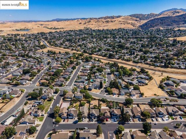 Aerial overview of property's location with nearby suburban area and a mountainous background