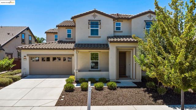 Mediterranean / spanish-style home featuring a garage, driveway, and stucco siding