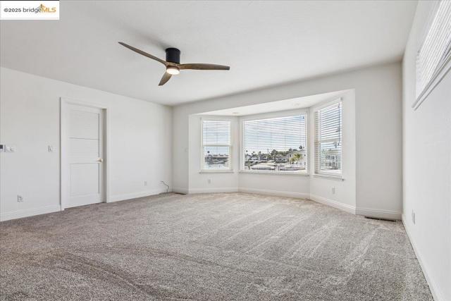 Unfurnished bedroom featuring carpet floors and ceiling fan