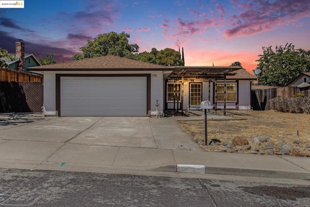 Ranch-style home with driveway, roof with shingles, and a garage