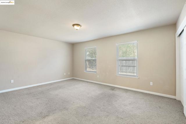 Spare room with light colored carpet and a textured ceiling