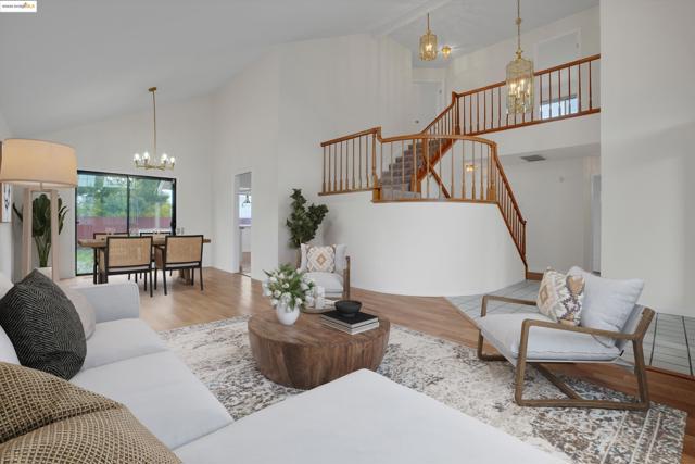 Living area featuring a chandelier, high vaulted ceiling, and wood finished floors