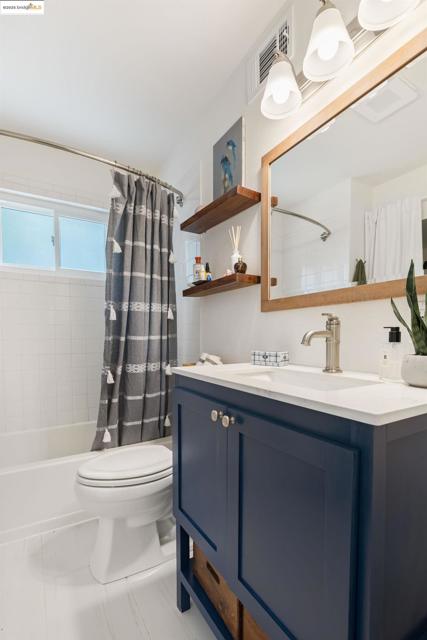 Full bath featuring shower / tub combo with curtain and vanity