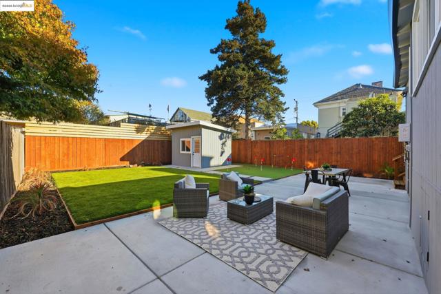 Fenced backyard with a patio, an outdoor structure, and an outdoor hangout area
