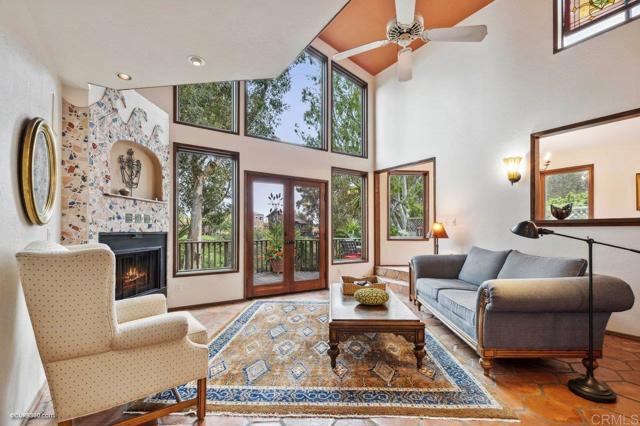 Living room with vaulted ceilings and floor-to-ceiling windows filled with natural light