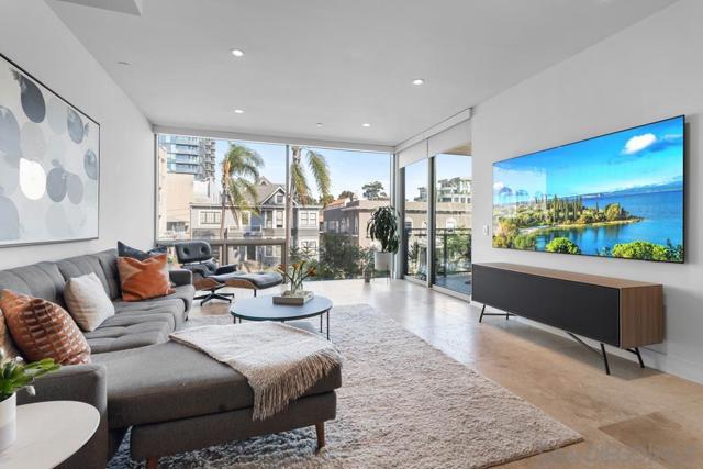 Living room featuring imported Turkish stone tile flooring, floor to ceiling windows, an 85