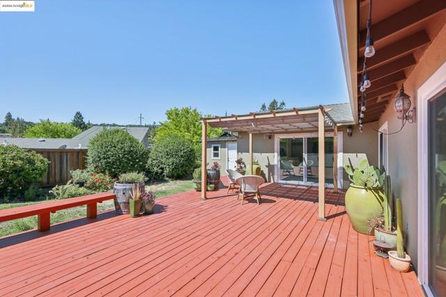 Deck featuring a pergola, a fenced backyard, and a storage shed
