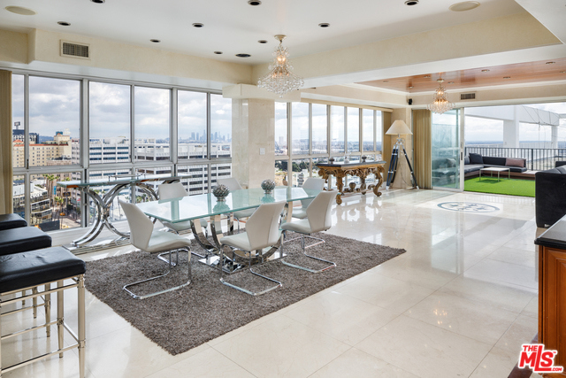 7135 HOLLYWOOD PHE Los Angeles, California Beautiful east facing penthouse unit with outdoor sundeck in the famed Versailles Tower. This three-bed, four bath unit features 3,580 SqFt and a light, bright and open floor plan thoughtfully designed to showcase California's indoor-outdoor lifestyle. Sweeping views of the Hollywood Sign and Griffith Observatory to the North, Downtown, Los Angeles to the East and Century City to the West. The fully equipped kitchen with large preparation island and adjacent wet bar with integrated seating is a focal point of the condo. It opens to an elegant dining space, naturally illuminated by floor to ceiling windows and panoramic bi-fold doors that invite guests to the rear outdoor space. Mid-century building offers 24-hour door man, valet parking, exercise facility, game room, swimming pool and sauna. Moments away from The Hollywood Roosevelt and Runyon Canyon Park.
