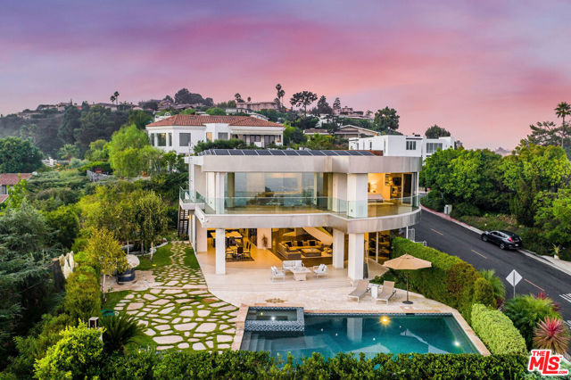 2235 Hercules Drive Los Angeles, California This stunning modern architectural estate is an entertainer's dream house, boasting an indoor/outdoor living experience with unobstructed views from Downtown Los Angeles to the Pacific Ocean. The home features a custom circular living area, a sleek modern European style kitchen with state of the art appliances, an entertainer's bar area, home theatre, office, and maid's quarters. The master suite includes a two-sided fireplace, reflective privacy glass, a private grand balcony to enjoy panoramic views, and a master bath with floor to ceiling marble, floating tub, rainfall shower/steam, and his/her bath closets. Experience the glass elevator on your way down to the lower level walk-in wine cellar and ten car subterranean garage. The unique exterior shape has a vast stainless steel trim, meticulously manicured backyard, Koi pond, and an infinity pool/spa.