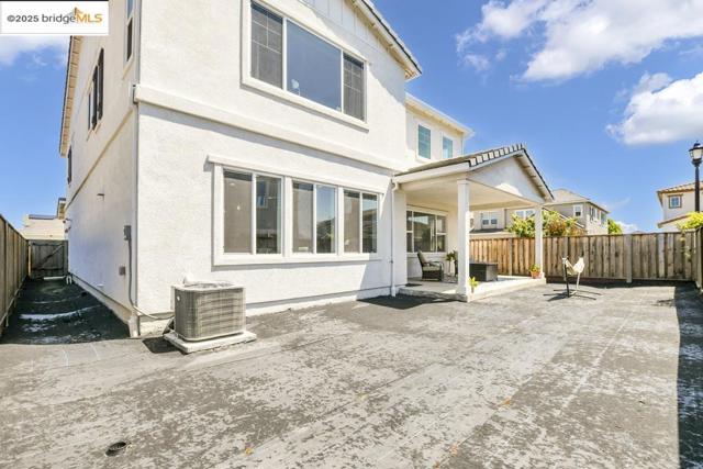 Rear view of house with a fenced backyard, a patio area, and stucco siding