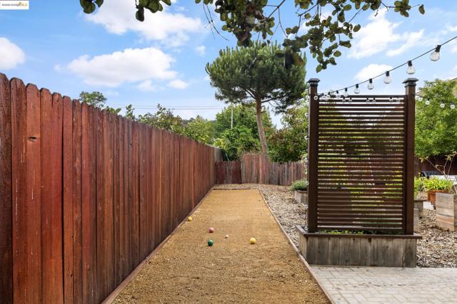 Fenced backyard featuring a game area