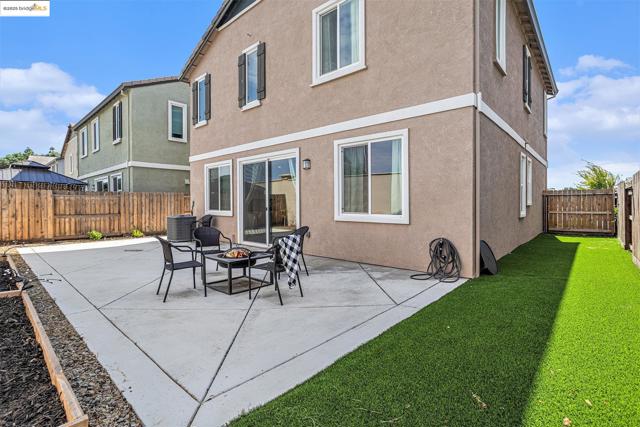 Rear view of house featuring an outdoor fire pit, a patio, stucco siding, and a fenced backyard