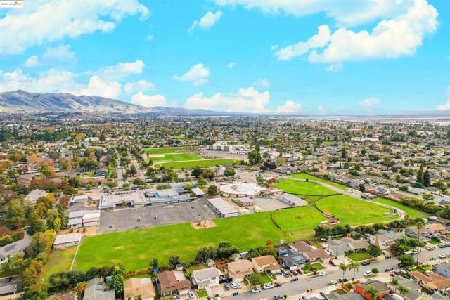 Aerial view of property and surrounding area with nearby suburban area and a mountainous background