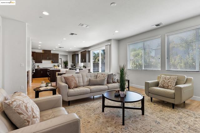 Living room with light wood-type flooring and recessed lighting