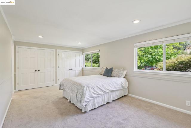 Bedroom featuring light colored carpet, ornamental molding, multiple closets, and recessed lighting