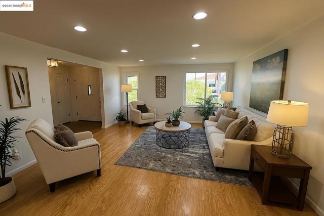 Living room with recessed lighting, light wood-style floors, and ornamental molding