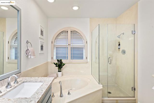 Bathroom with a bath, plenty of natural light, a shower stall, vanity, and recessed lighting