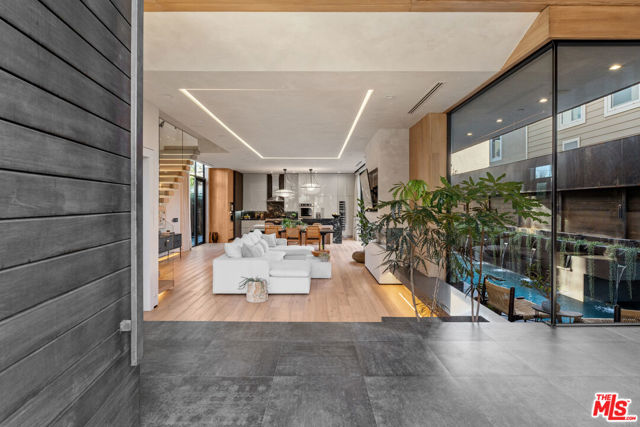 750 California Avenue Venice, California Located just minutes from Abbot Kinney's vibrant scene in Venice, this architectural marvel, shielded by a 12-foot wall, boasts a fusion of contemporary comforts and distinctive finishes, embodying Southern California's indoor-outdoor lifestyle. With a chef's kitchen, expansive outdoor spaces, a serene lounge, office, roof terrace, gym, and pool, it offers ample relaxation. The rooftop, perfect for gatherings under California sunsets, features a fireplace, BBQ area, and TV for unparalleled entertainment. The four spacious bedrooms, each with a full bathroom, ensure privacy, while the master suite dazzles with skylights and a walk-in closet. Rare private parking adds convenience, making this home an entertainer's dream. Adorned with state-of-the-art glass, it exudes comfort with beige walls and marble countertops, epitomizing luxury living in Venice.
