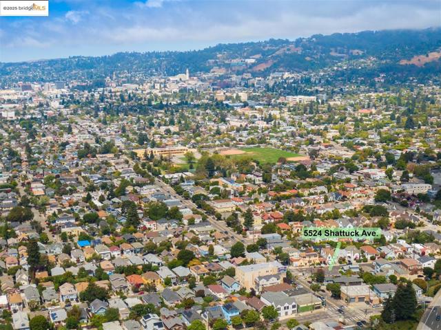 Aerial view of property and surrounding area featuring nearby suburban area