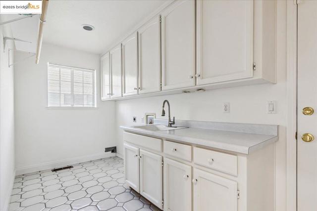 Laundry room with washer hookup, cabinet space, hookup for an electric dryer, and light flooring