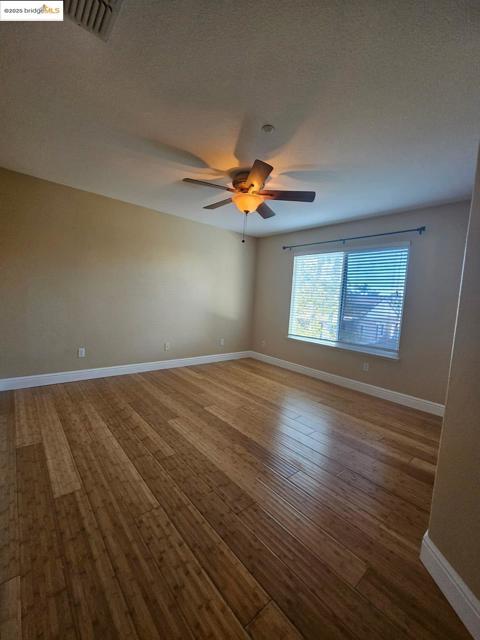Spare room featuring a textured ceiling, wood finished floors, and ceiling fan