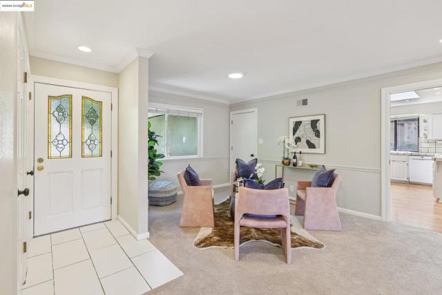 Entrance foyer featuring light colored carpet, crown molding, and recessed lighting