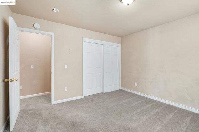 Unfurnished bedroom with light colored carpet and a closet