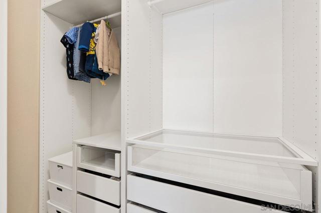 Custom-built closet with lots of drawers on both walls.