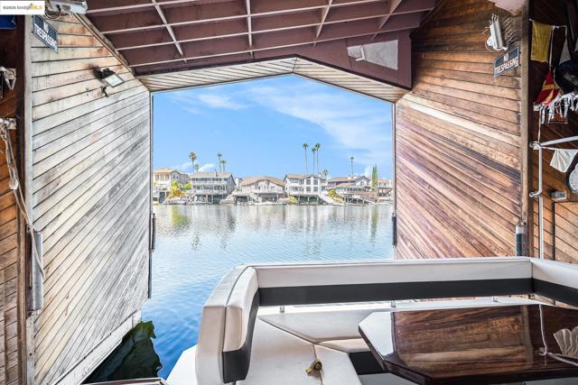 Dock area with a water view, a residential view, and a balcony