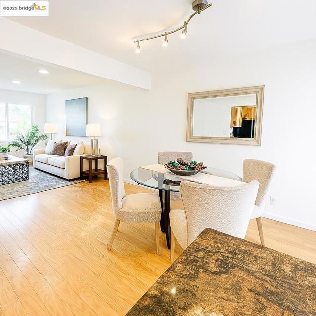 Dining area with light wood-style floors and recessed lighting
