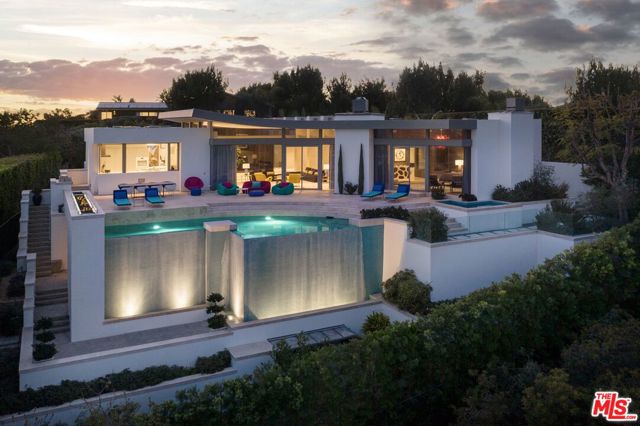 1486 BLUE JAY Way Los Angeles, California A timeless architectural, designed to capture the site's explosive views of Downtown Los Angeles. Mature hedges and a cascading water feature create a serene private courtyard with walls of glass framing views of the city through the house upon arrival. Enter into a grand scale living room flooded with natural light and Terrazo floors seamlessly blending the home's lavish entertaining spaces. An exquisite Master suite provides Head on views of the city and the highest level of amenities throughout, from the backlit boutique walk-in closet to the tub looking out to its private Zen garden. A Bulthaup kitchen provides the ultimate in chef's amenities whilst offering views over the city, just steps away from the formal dining room. An oversized deck complete with built in BBQ, Fire pit and infinity pool allows for the ultimate outdoor entertaining. A large gym, home office and wellness center complete this turnkey view estate.