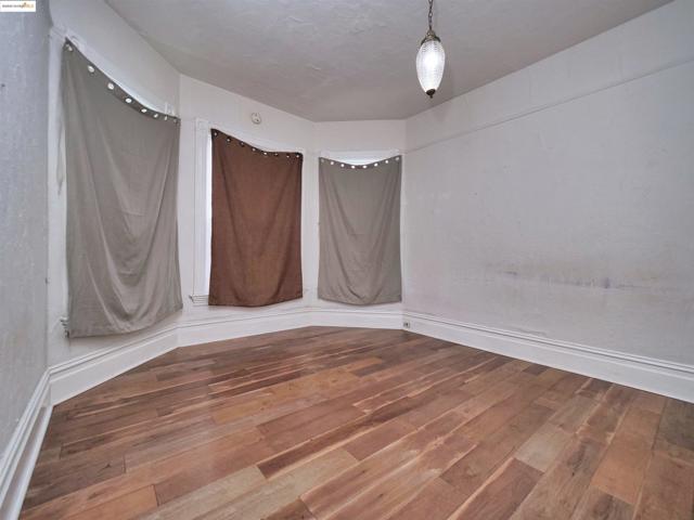Unfurnished room with wood-type flooring and baseboards