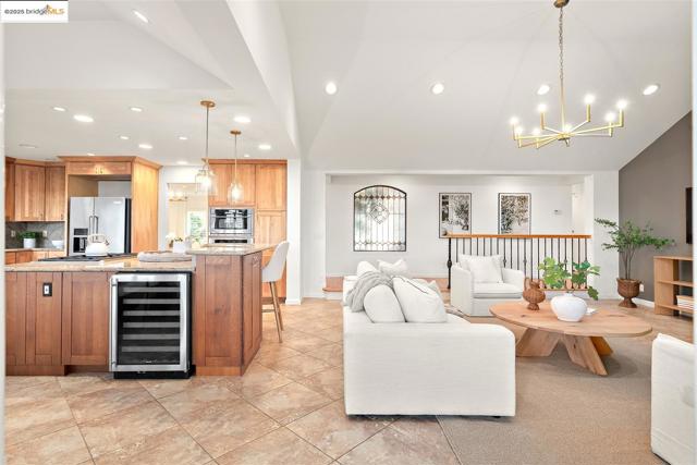 Living room featuring a chandelier, beverage cooler, recessed lighting, and vaulted ceiling