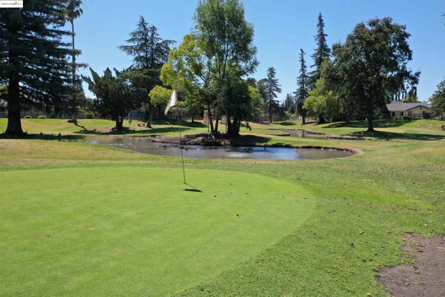 Surrounding community with view of golf course, a water view, and a lawn