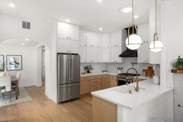 The gourmet kitchen boasts Quartz counters, stainless steel appliances including a french door refrigerator and 6 burner stove, sleek cabinetry, and a spacious pantry with a espresso station, perfect for culinary enthusiasts.