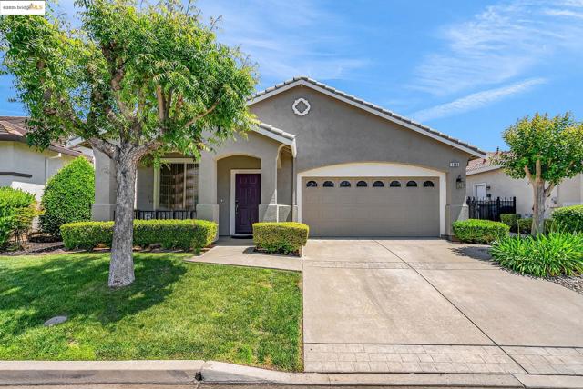 View of front of home with a garage, stucco siding, driveway, and a tile roof