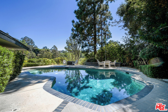 9545 Hidden Valley Road Beverly Hills, California Rare sprawling residence, flush with Mid-Cent Lloyd Wright-esque influences like deep overhanging eaves, floor to ceiling glass, clean lines & utter privacy, in 24/7 guarded Hidden Valley Colony. Recent sales at $17MM, yards away & other $30+MM valued homes, make this an ideal opportunity to expand/renovate/redevelop the large site w/gated drive or move and get a toe hold as resident in the least expensive home to sell in the Colony in years. Multiple A-list Celeb neighborhood w/discrete clientele. 1st flr: open concept liv/din flowing to generous patios & pool w/cyn views, plus 2 bds & 2 bas. Upstairs, enormous 2 bd/2 ba ste, superb bed ste/in laws. Topping it off: 2 blocks down this pvt rd is the residents only access gate to Franklin Canyon walking trails, lake & nature center, including vast seldom used open space. A green, pastoral environment, like living in Topanga or Malibu countryside, yet 5 minutes to the BH Hotel & equally easy access to Sherman Oaks/Studio City.