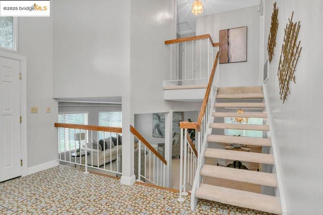 Stairs featuring a high ceiling and baseboards