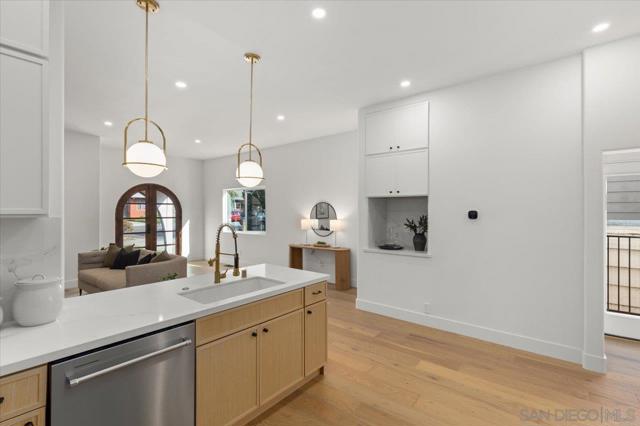 The gourmet kitchen boasts Quartz counters, stainless steel appliances including a french door refrigerator and 6 burner stove, sleek cabinetry, and a spacious pantry with a espresso station, perfect for culinary enthusiasts.