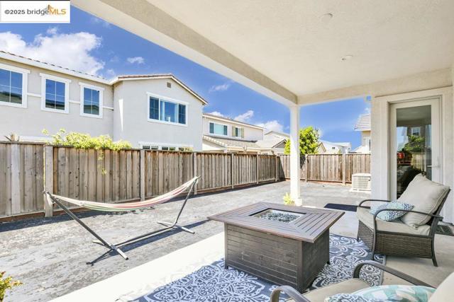 Fenced backyard with a patio area and an outdoor living space with a fire pit