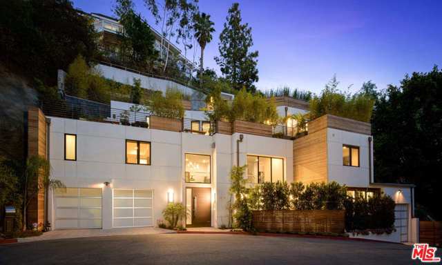 1414 Dawnridge Drive Beverly Hills, California Nestled away just moments from the best of Beverly Hills, awaits this warm contemporary oasis. A serene retreat, the home sits at the end of a private cul de sac and is enveloped by lush hedges & soaring trees. The voluminous open floor plan mesmerizes all upon entry with a dramatic double height entry, opulent fireplace and seamless flow through all spaces. A chef's dream, the sleek custom kitchen boasts eat-in island, extensive cabinetry, top-of-the-line stainless steel appliances, wine fridge, and stylish tile backsplash. At days end, escape to the second level where you will find generous guest suites and the luxurious primary with spa-like bath. This is a true entertainer's paradise with sweeping, multi-level decks where you can host al fresco meals, enjoy an outdoor workout, or plant a garden. Additional amenities include sliding glass doors for indoor/outdoor living, elevator, three car garage parking, and so much more. California living at its finest, this BHPO estate truly has it all!