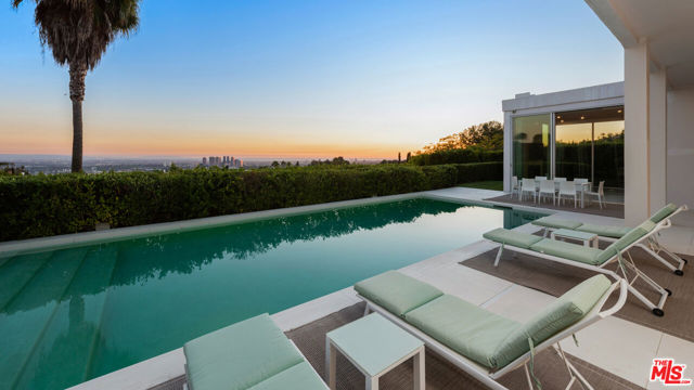 Reimagined in 2016, this stunning, classic-modern Trousdale home makes an unparalleled statement of vision & design while showcasing breathtaking panoramic vistas from cityscape to coastal ocean views. The completely private, gated, and hedged property is on an ~28,000 sq. ft. lot following a private driveway in prime Trousdale Estates. The house is flawlessly designed & crafted with ~12'6" ceilings, floor-to-ceiling windows/doors, and seamlessly integrated interior & exterior spaces for the ultimate California lifestyle. The home's paneled entrance gallery features impressive floor-to-ceiling doors and an elegant courtyard fountain. Complementing the home's classic modern architecture are the spacious living room with fireplace & sunken bar, a den, formal dining room, and a family room with fireplace. Adjoining the family room is a chef's kitchen with island & Miele appliances. Bedroom suites consist of three guest bedroom suites and a master suite with a custom walk-in closet & luxurious bathroom. Overlooking the incredible city to sea views for which Trousdale is well known, the property's outdoor spaces include covered & open patios, and a pool & spa.