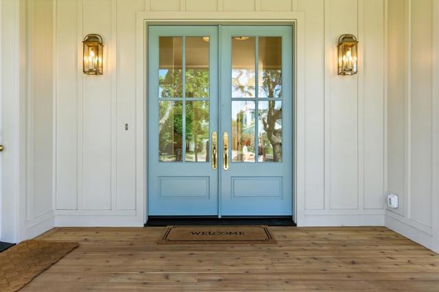 Covered porch with wood decking and glass double doors.