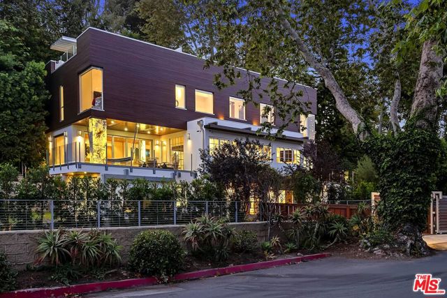309 E Rustic Road Santa Monica, California Situated in the coveted Santa Monica Canyon, this architectural gem fuses luxury and sophistication with tranquil living. Lush landscaping and rich waterfalls surround the entrance of this private property. This multi-level, light filled smart home has 4 bedrooms, 4.5 bathrooms, and a state-of-the-art rooftop deck with a full outdoor kitchen, fire pit, and views of the ocean. On the first level, you will find a two-car garage, one en-suite guest bedroom and a meticulously crafted exercise room. On the second level, you will find a stunning gourmet kitchen with prep area equipped with high end appliances and Onyx back-lit countertops that all open up to a large family room with a fireplace, dumbwaiter, and exotic bamboo wood encompassing the entire second floor ceiling. The family room also has floor to ceiling doors that open up to a large deck with, sitting area and custom hammock welcoming the nearby ocean breeze. On the upper level, you will find two secondary en-suite bedrooms and a primary bedroom with an adjoining sitting room/exercise room, spa like master bath, and a large master closet that all open up to a private backyard with a pool and fire pit. This home is ideally located, just minutes from the Caruso Village and Santa Monicas renowned dining, shopping, and beaches.
