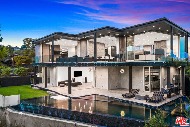 701 Rochedale Way Los Angeles, California Perched at the end of a quiet cul-de-sac stands this custom modern trophy estate. Stunning views of DTLA, the coastline, and Crestwood Hills from every angle, as if you are floating on air. Designed around the art of entertaining, floor to ceiling glass panels seamlessly disappear & integrate the view, the outdoors, the wrap around deck and the interior space. This private oasis is truly a must see in person to experience the energy and privacy. A modern floor plan that features a large sleek fully equipped chefs kitchen, an oversized dining room & an enormous living room that overlooks the captivating views. The main suite rivals any 5-star hotel, with an oversized walk-in closet & spa like bathroom. The lower level consists of a gym, family room, glass wine room, & movie theater. Featuring 5 en-suite bedrooms and 8 baths laid out over 7,040 SF, a dramatic infinity pool, grassy pad and tons of space to bask in the sun and enjoy the So Cal weather. The ultimate modern view home.