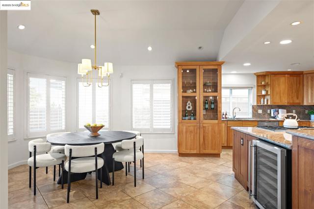 Kitchen with beverage cooler, pendant lighting, light stone countertops, recessed lighting, and open shelves